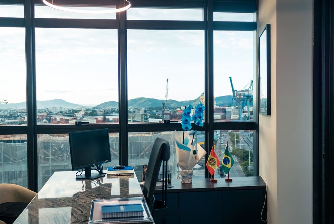 Ambiente de trabalho da Regência Contabilidade, com vista para o cais e os guindastes do porto.